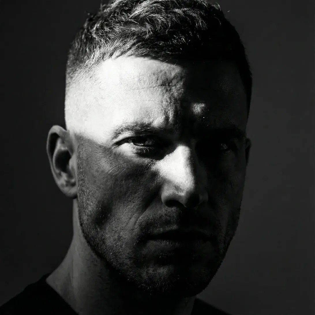 Tight black-and-white close-up portrait with slivers of light over eyes and cheekbones